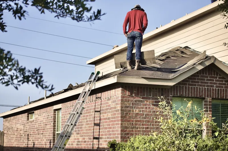 Professional roofer working on a residential roof in Kincaid